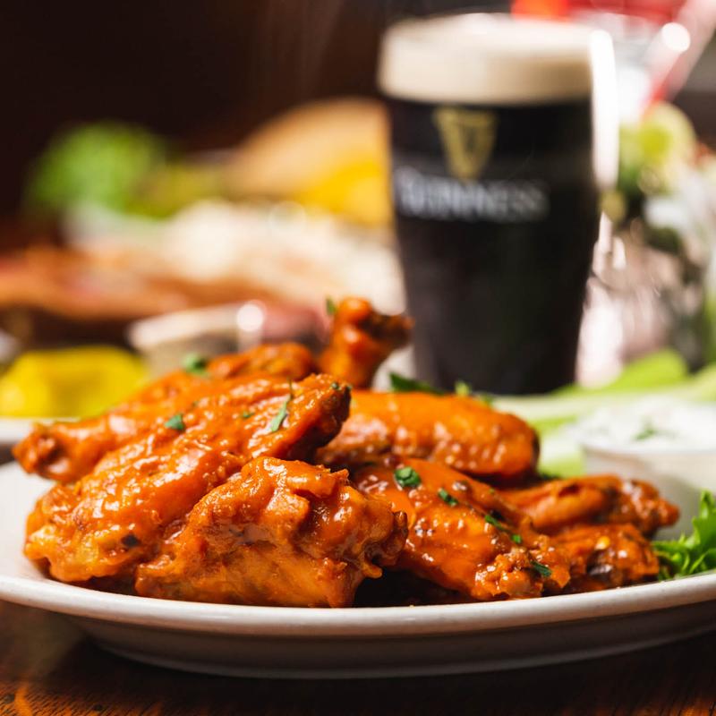 A plate of buffalo wings with a pint of Guinness at Old Town Bar