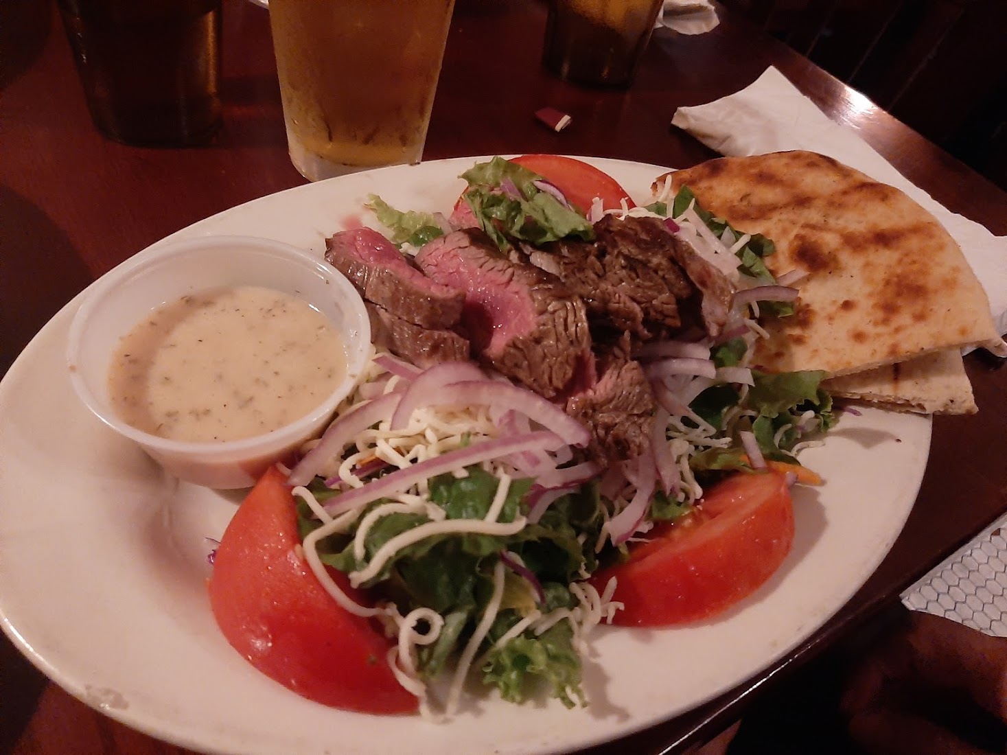 A grilled steak salad with warm pita